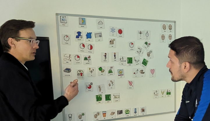 Widgit and Chelsea FC representatives discussing symbols on a whiteboard